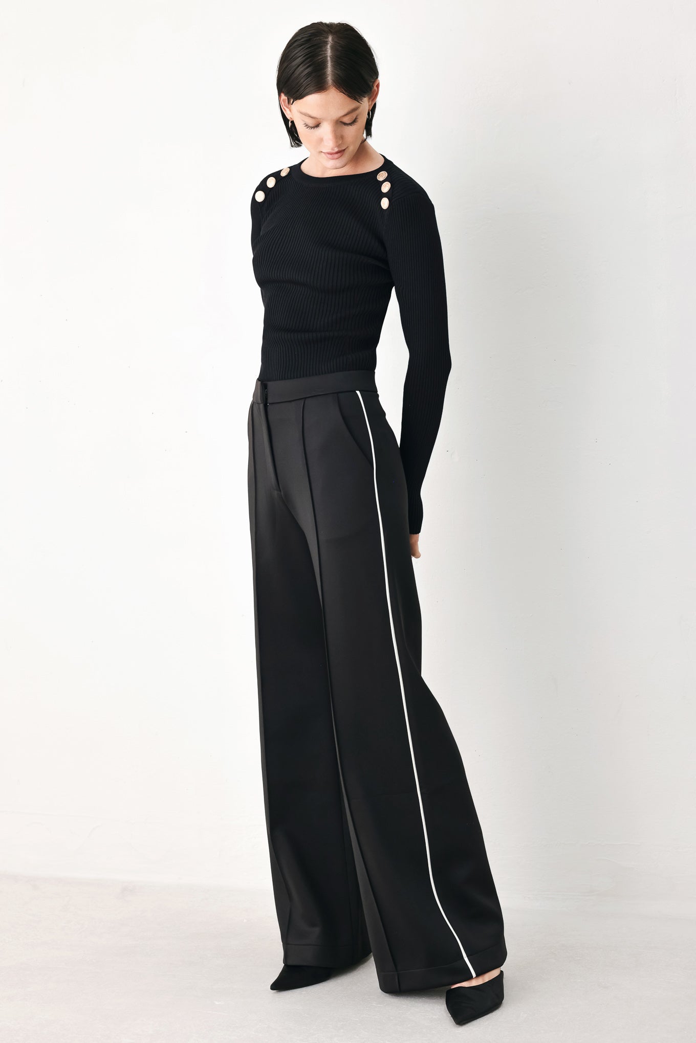 Model wearing black wide-leg trousers with white side stripes | FREEMARKET
