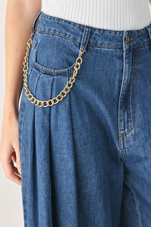 Woman wearing a pair of extra wide-leg blue denim jeans with front closure, pockets, pleats, and chain detail | FREEMARKET