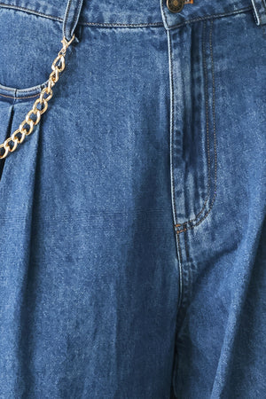 Woman wearing a pair of extra wide-leg blue denim jeans with front closure, pockets, pleats, and chain detail | FREEMARKET