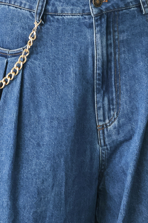 Woman wearing a pair of extra wide-leg blue denim jeans with front closure, pockets, pleats, and chain detail | FREEMARKET