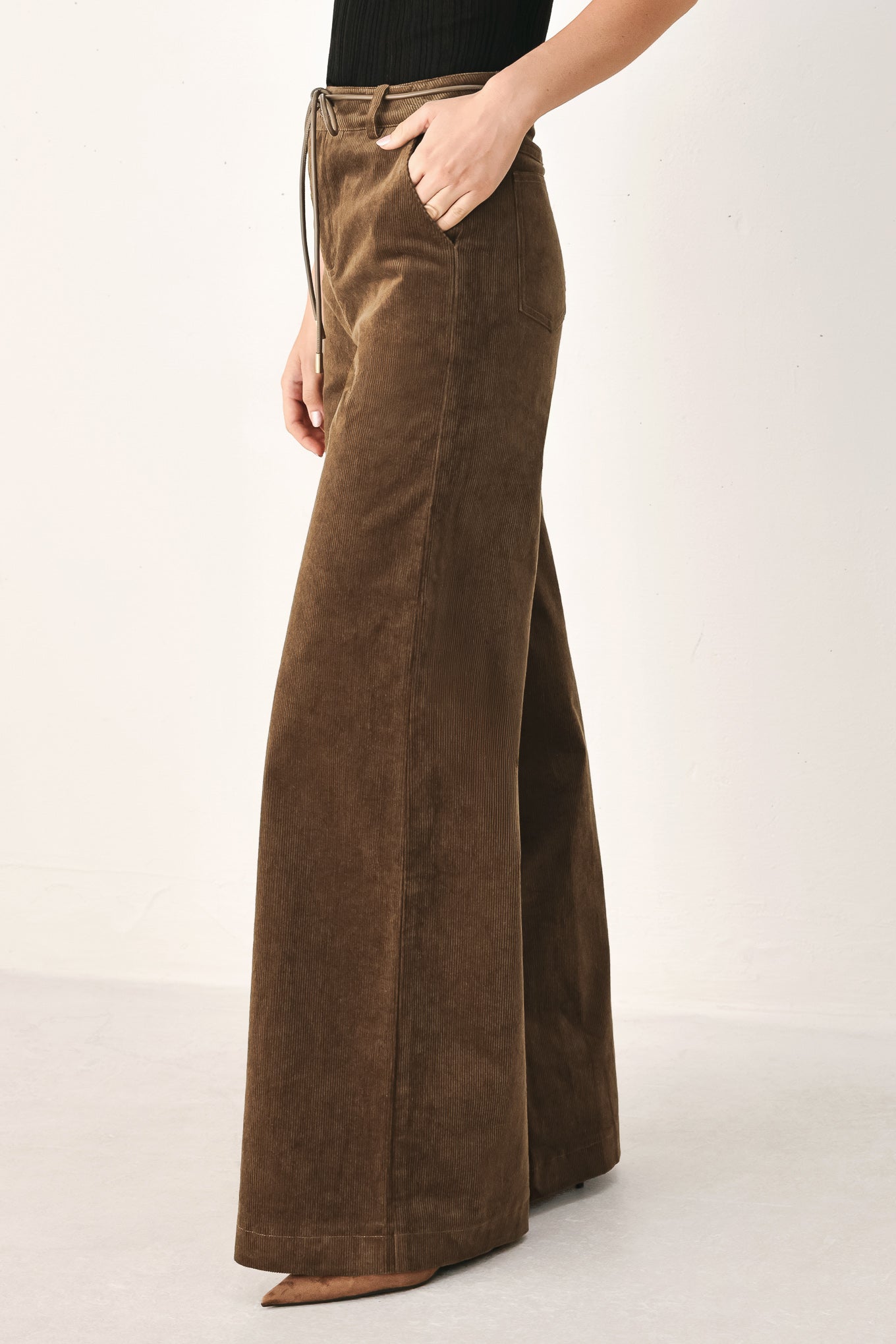 A model wearing high-waisted, wide-leg brown corduroy pants with a drawstring waist | FREEMARKET