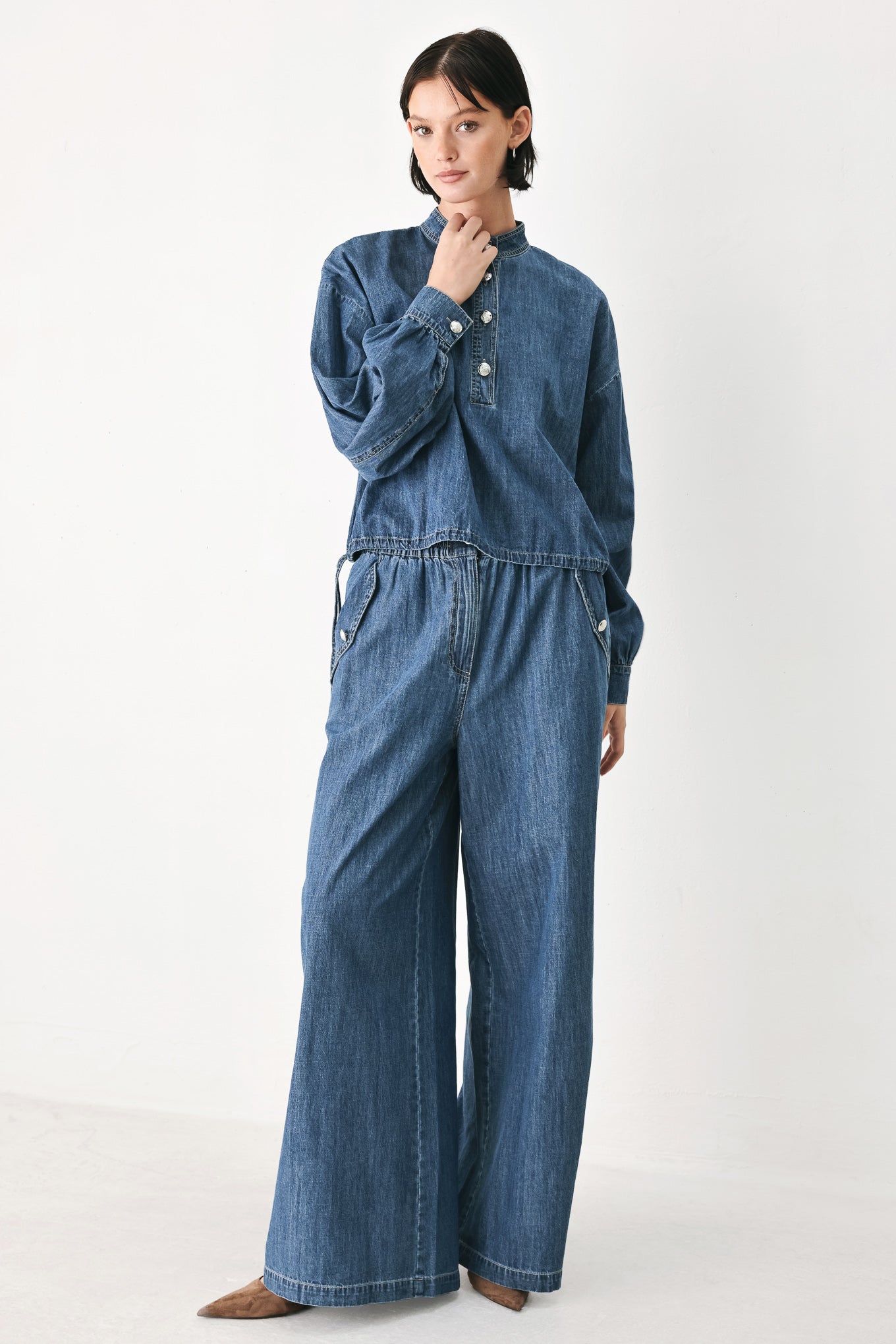 A person wearing wide-leg blue denim jeans with an elastic waistband, side pockets, and a button closure | FREEMARKET