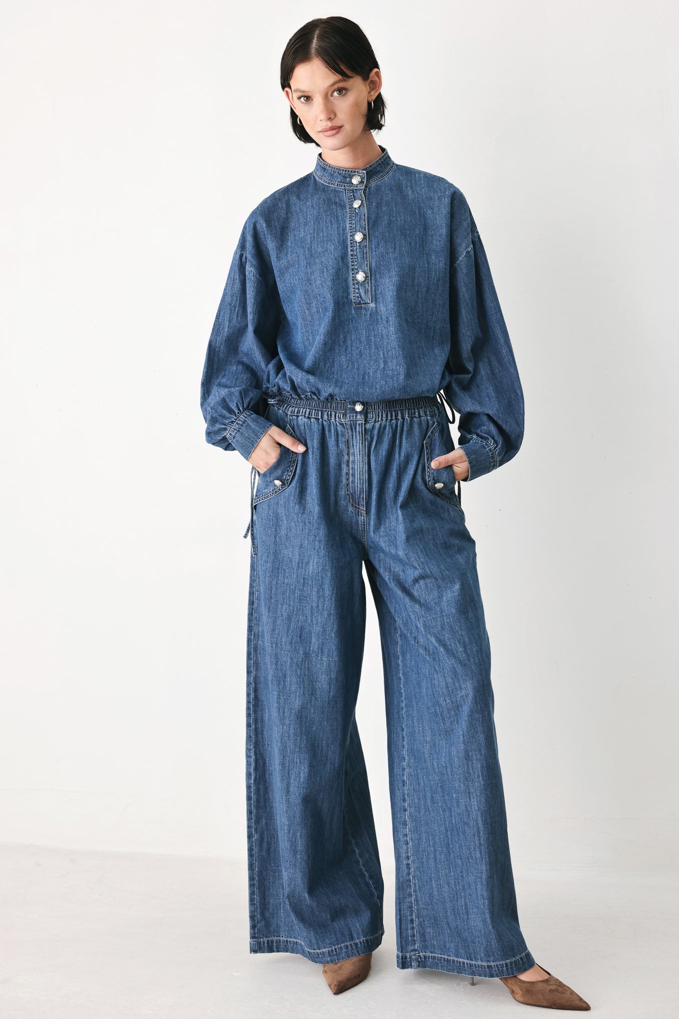 A person wearing wide-leg blue denim jeans with an elastic waistband, side pockets, and a button closure | FREEMARKET