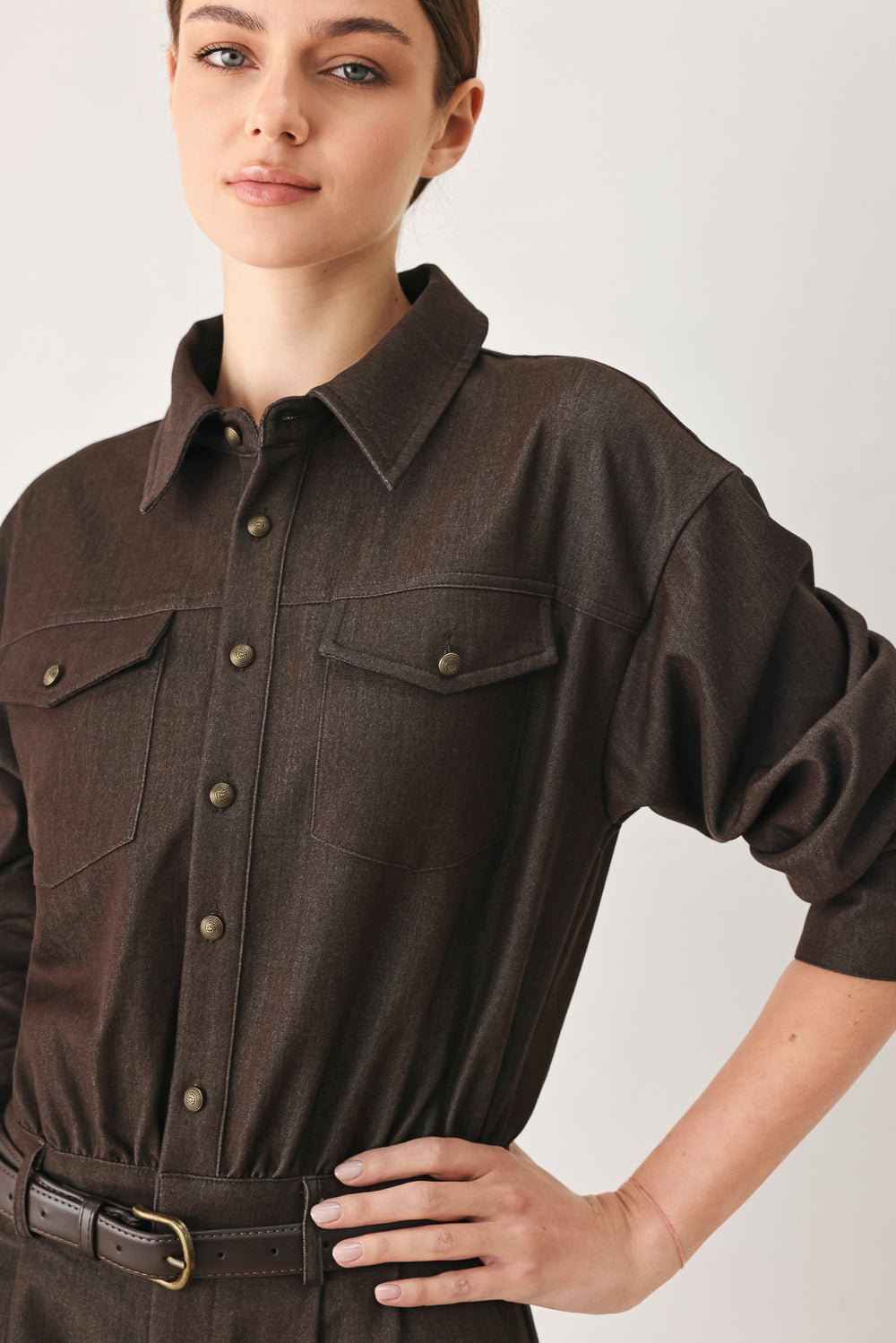 Woman wearing a brown woven romper featuring front button zipper closure, pockets, long sleeves and contrasting belt | FREEMARKET