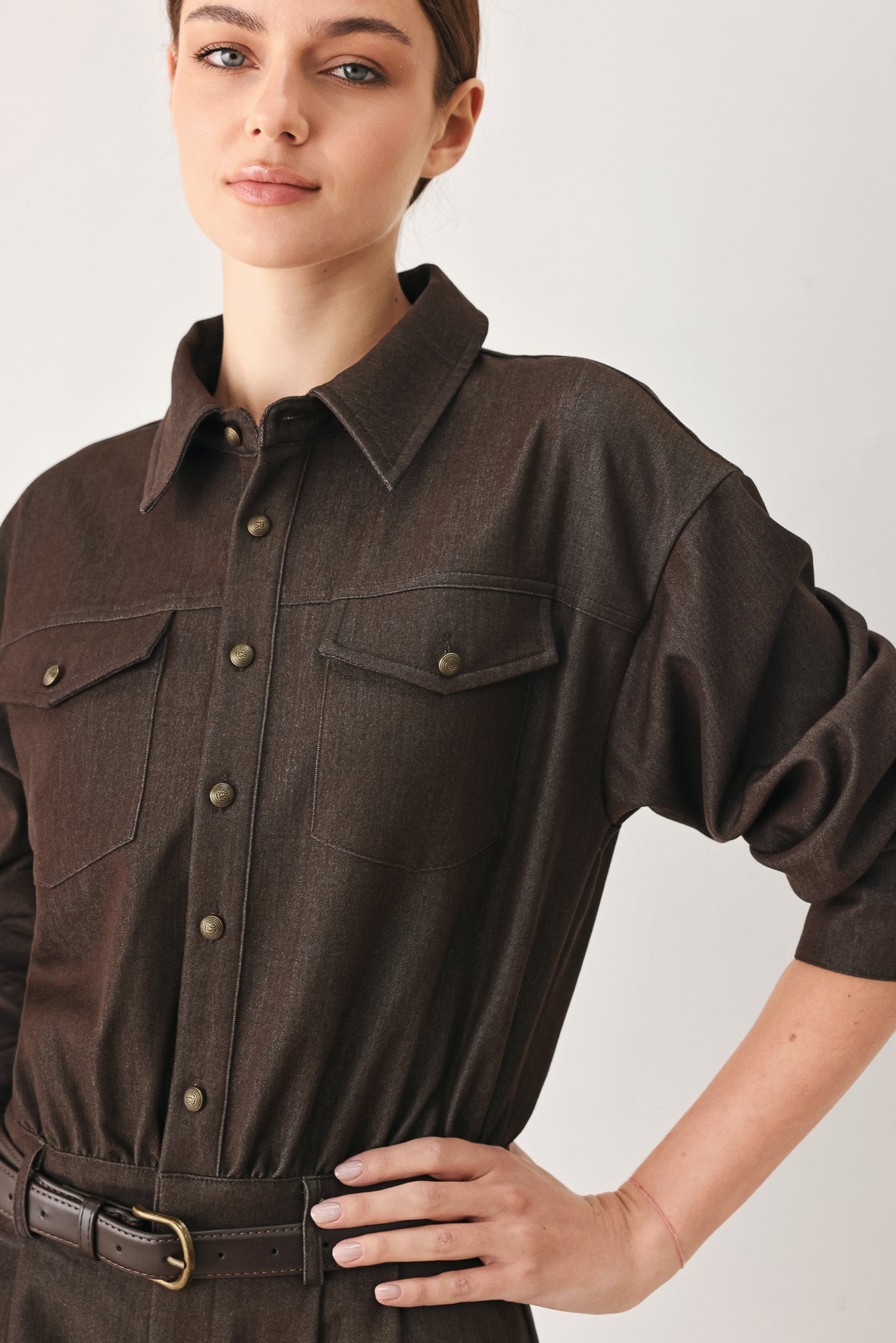 Woman wearing a brown woven romper featuring front button zipper closure, pockets, long sleeves and contrasting belt | FREEMARKET