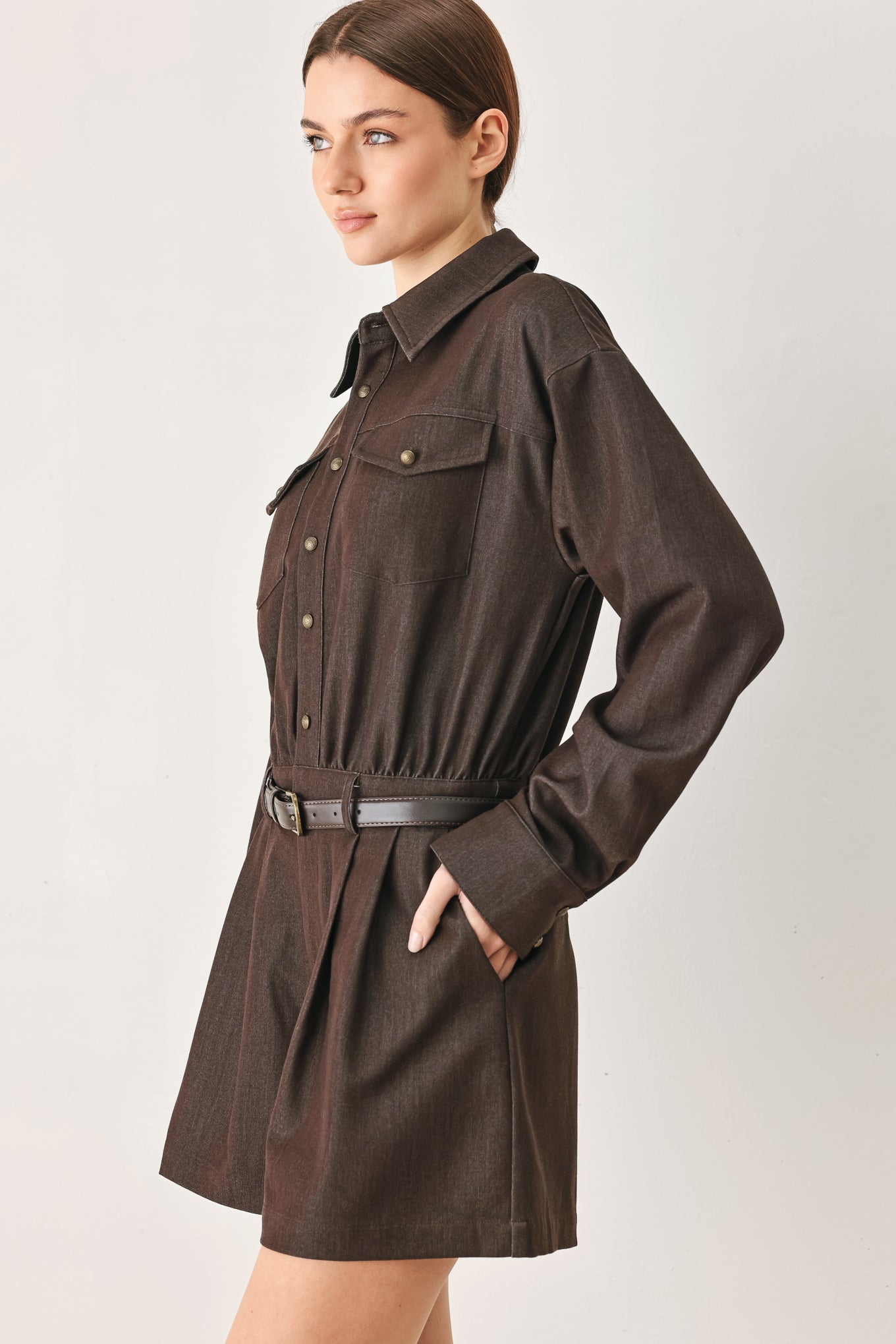 Woman wearing a brown woven romper featuring front button zipper closure, pockets, long sleeves and contrasting belt | FREEMARKET
