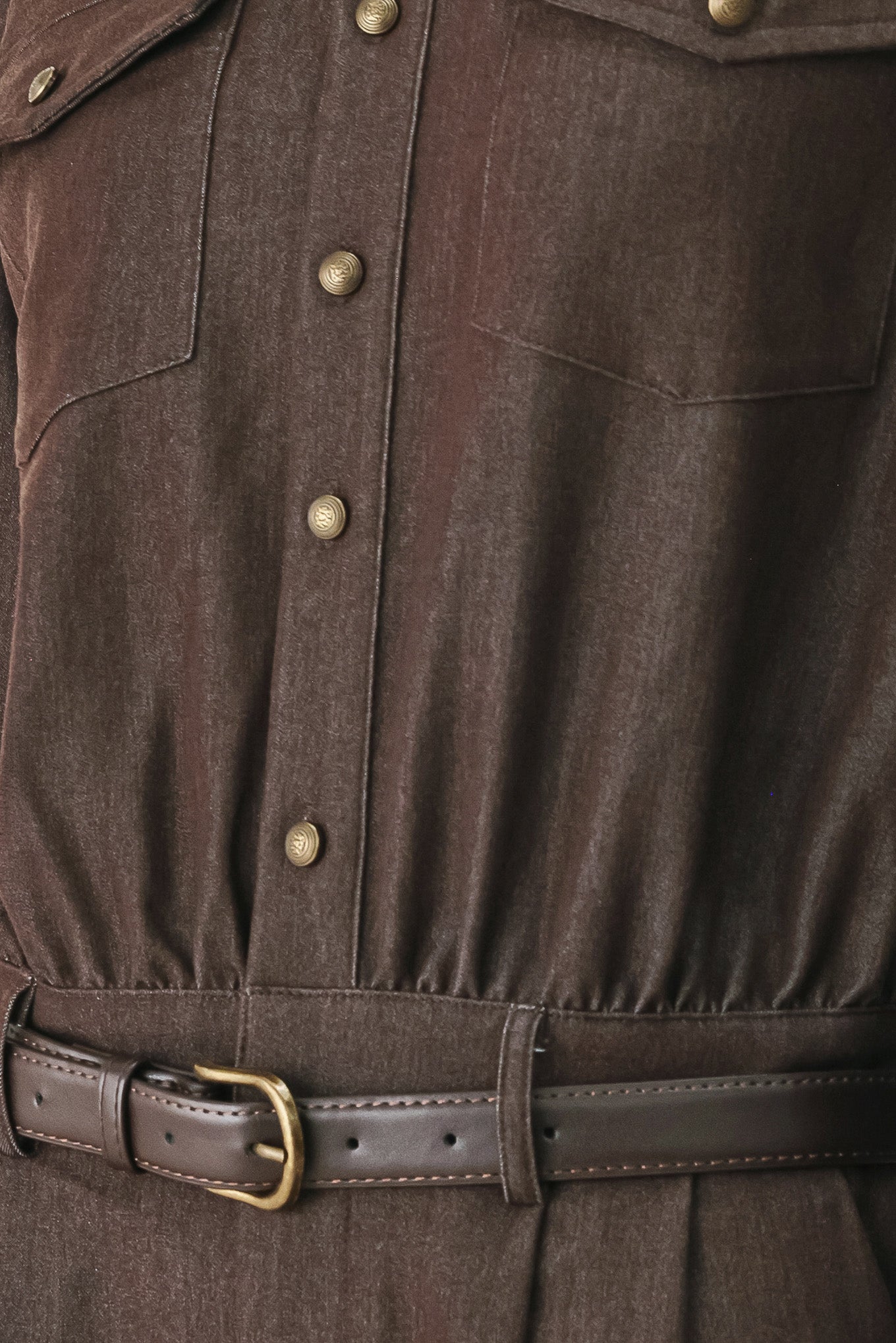 Woman wearing a brown woven romper featuring front button zipper closure, pockets, long sleeves and contrasting belt | FREEMARKET