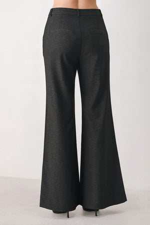 Woman wearing black high waisted pants with gold button details around the side calf | FREEMARKET