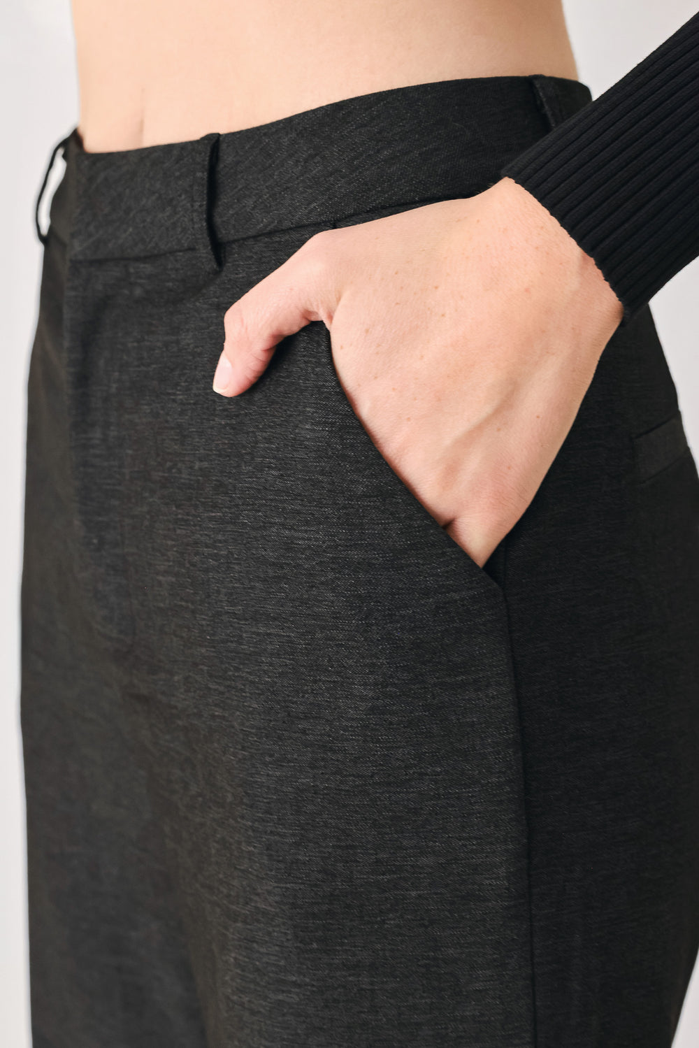 Woman wearing black high waisted pants with gold button details around the side calf | FREEMARKET