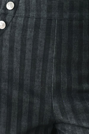 A model wearing a pair of high-waisted, wide-leg trousers in a dark gray and black pinstripe pattern, featuring decorative silver buttons on the front waistband | FREEMARKET