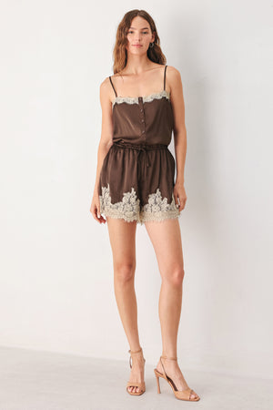 A woman wearing a brown satin romper with beige lace trim at the neckline | FREEMARKET