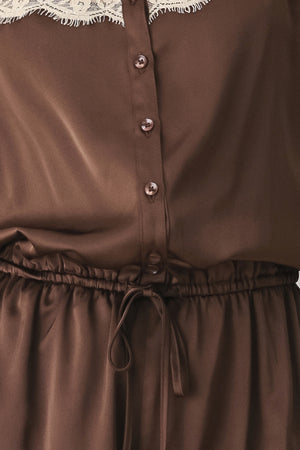 A woman wearing a brown satin romper with beige lace trim at the neckline | FREEMARKET