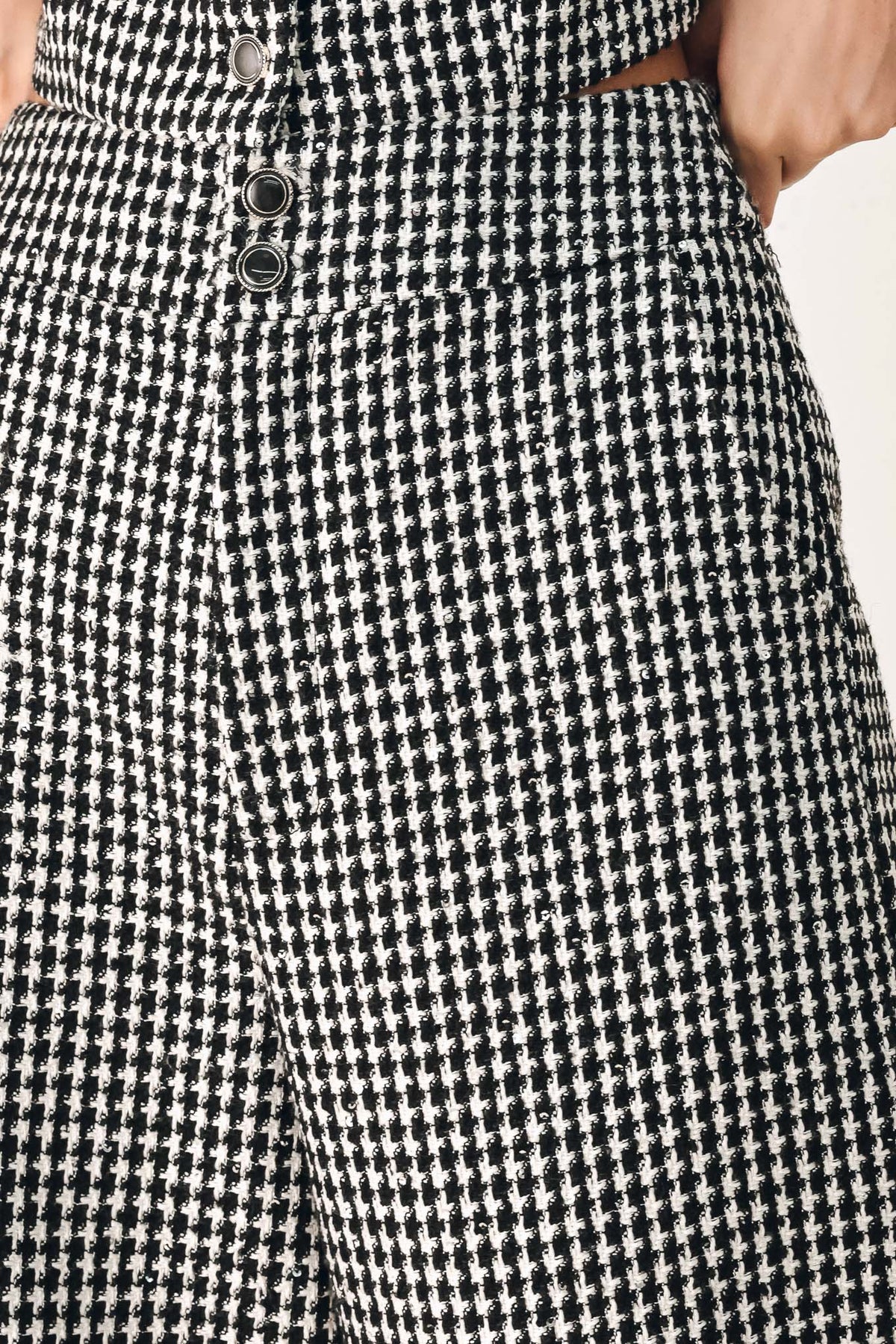 A person wearing high-waisted, wide-leg trousers with a black and white houndstooth pattern | FREEMARKET