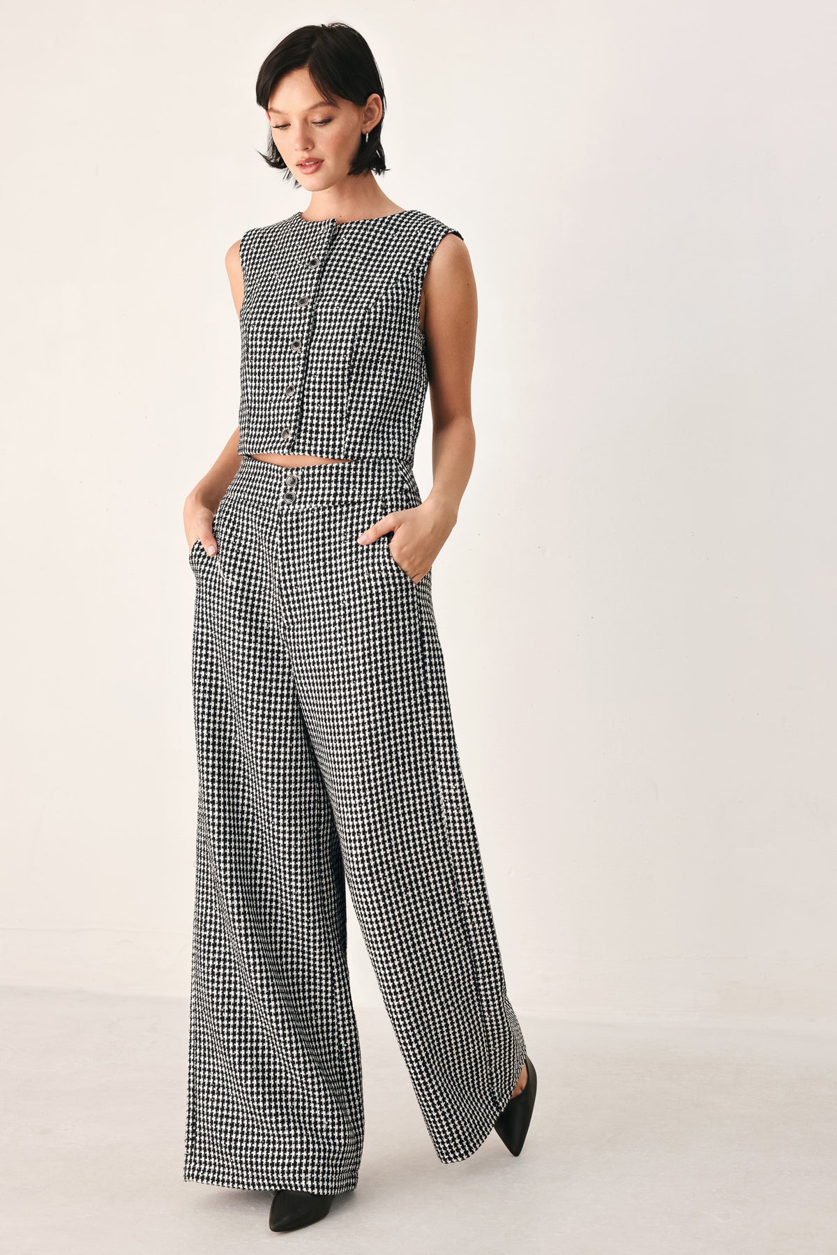 A person wearing high-waisted, wide-leg trousers with a black and white houndstooth pattern | FREEMARKET