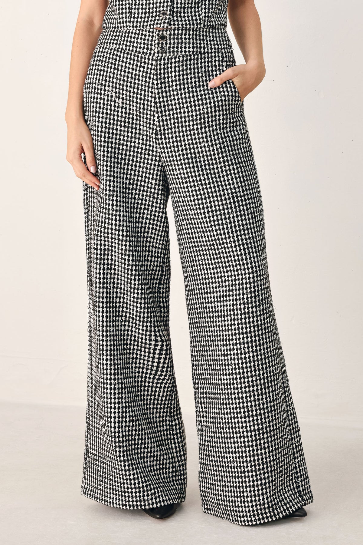 A person wearing high-waisted, wide-leg trousers with a black and white houndstooth pattern | FREEMARKET