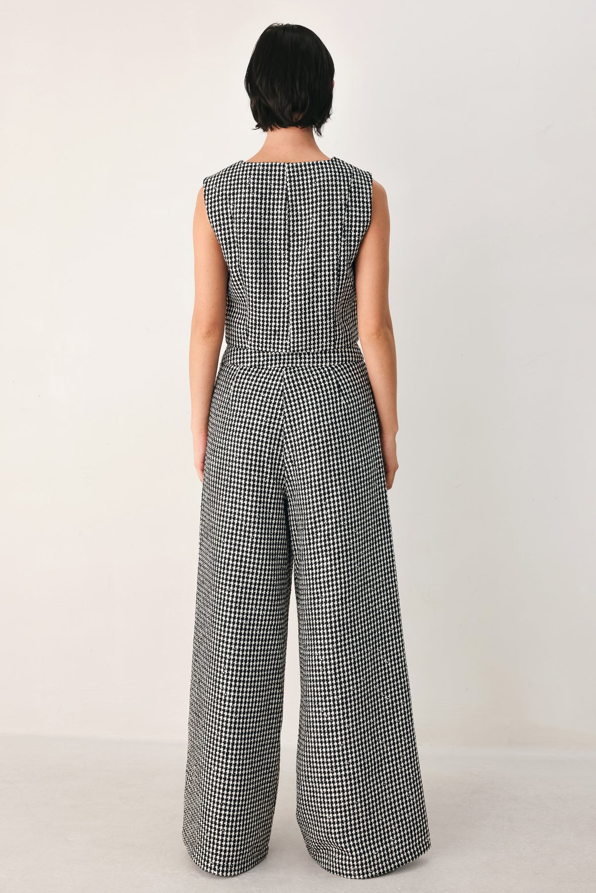 A person wearing high-waisted, wide-leg trousers with a black and white houndstooth pattern | FREEMARKET