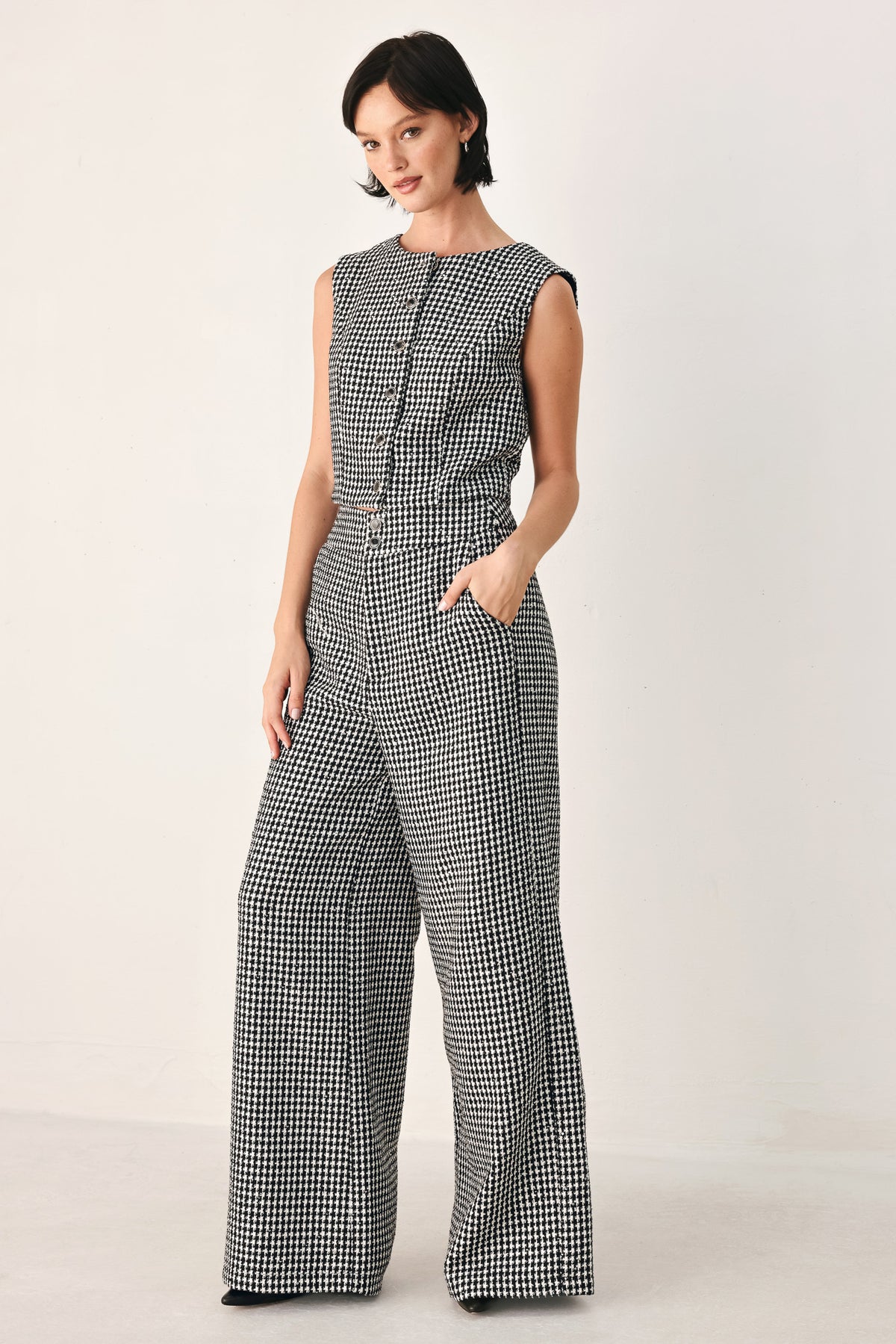 A person wearing high-waisted, wide-leg trousers with a black and white houndstooth pattern | FREEMARKET