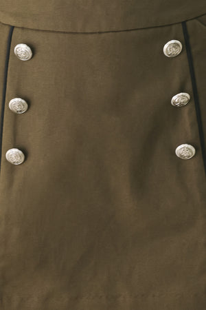 A woman wearing an olive green mini skort with double-breasted silver buttons | FREEMARKET