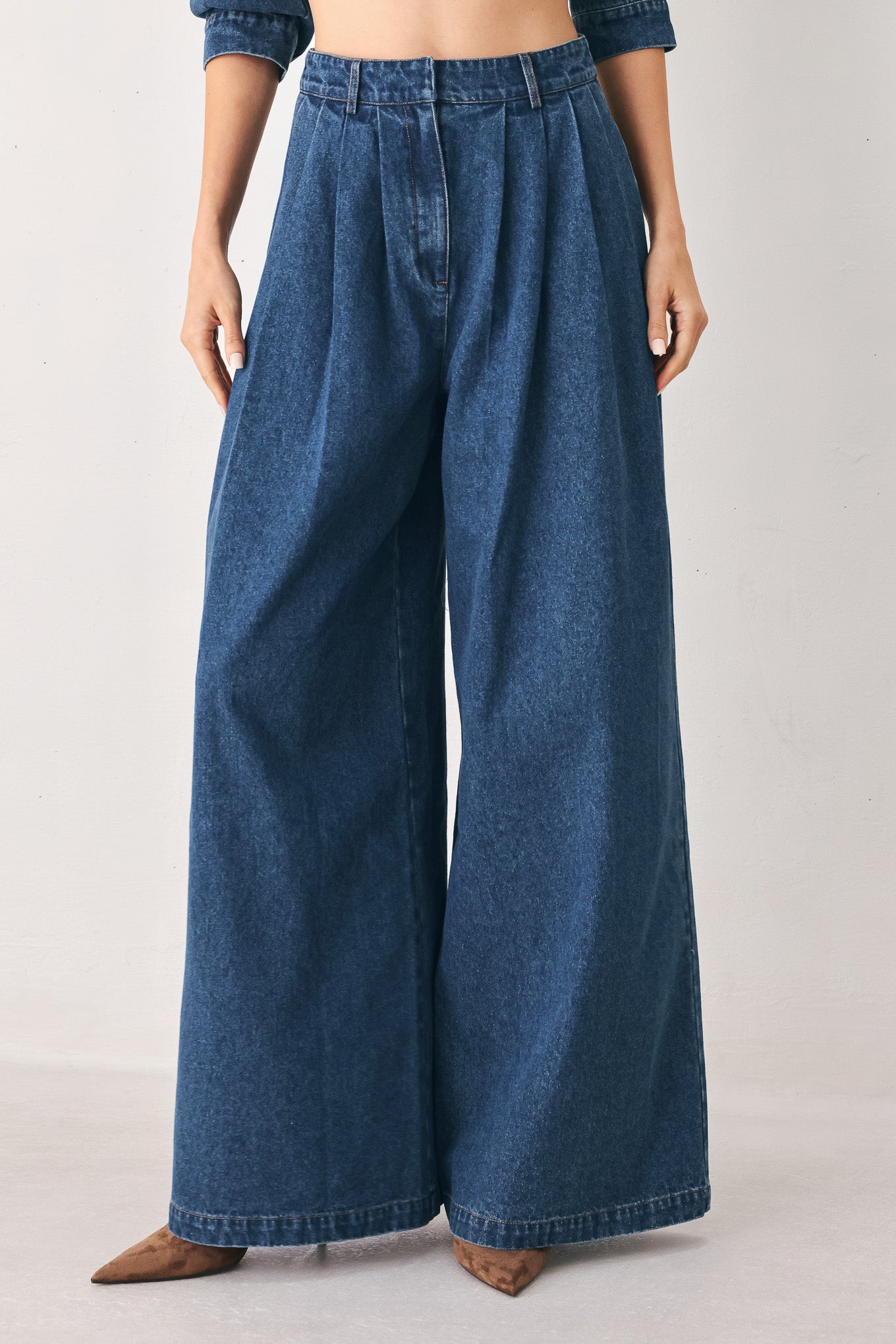A woman wearing high-waisted, wide-leg blue denim pants with a wide-leg fit | FREEMARKET
