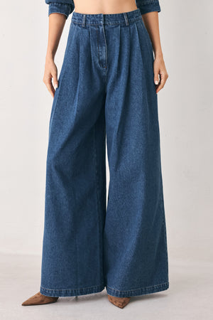 A woman wearing high-waisted, wide-leg blue denim pants with a wide-leg fit | FREEMARKET