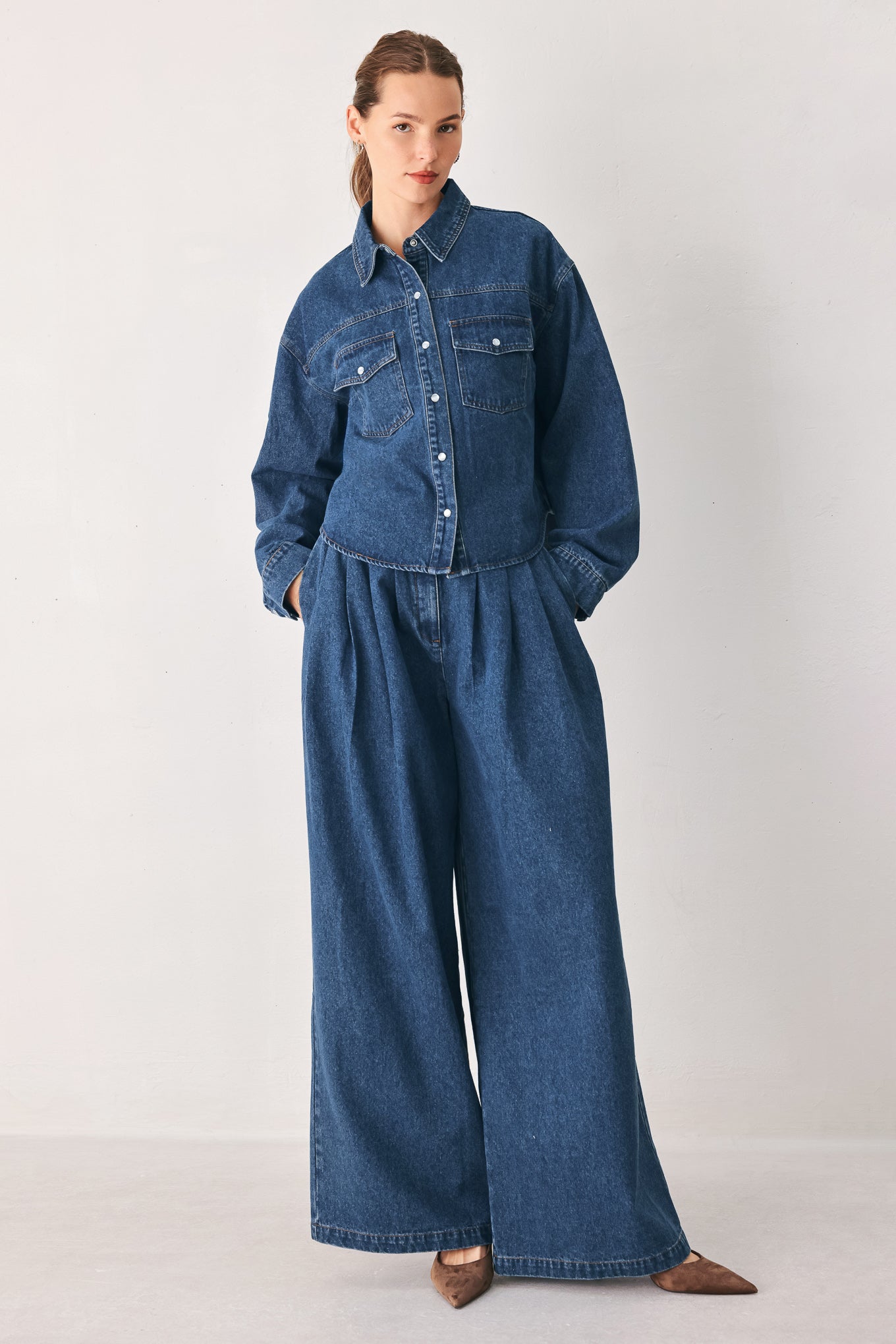 A woman wearing high-waisted, wide-leg blue denim pants with a wide-leg fit | FREEMARKET