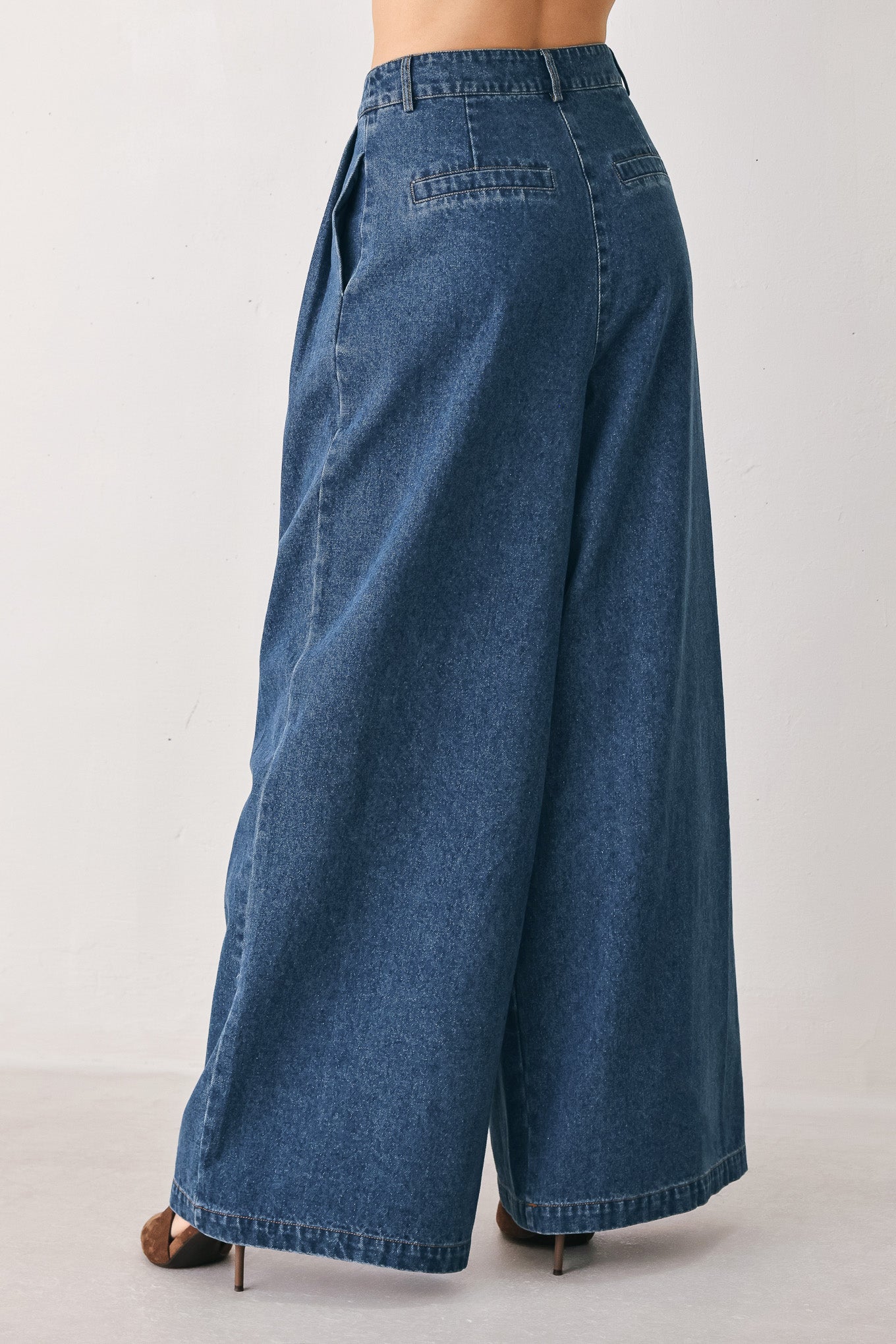 A woman wearing high-waisted, wide-leg blue denim pants with a wide-leg fit | FREEMARKET