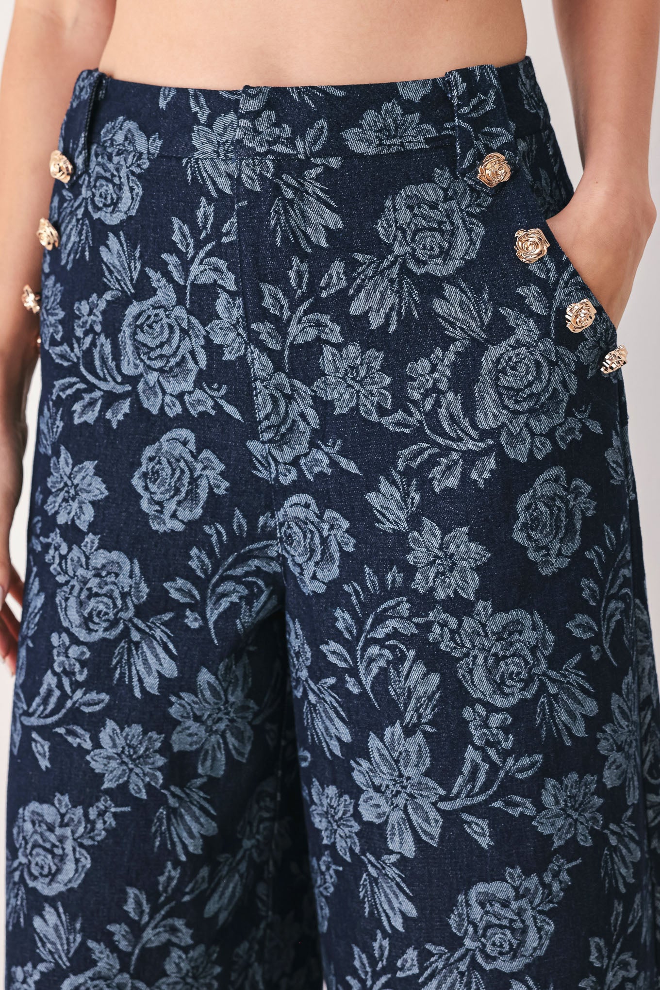 A woman wearing navy wide-leg jacquard pants with a light blue floral pattern and decorative buttons on the side | FREEMARKET