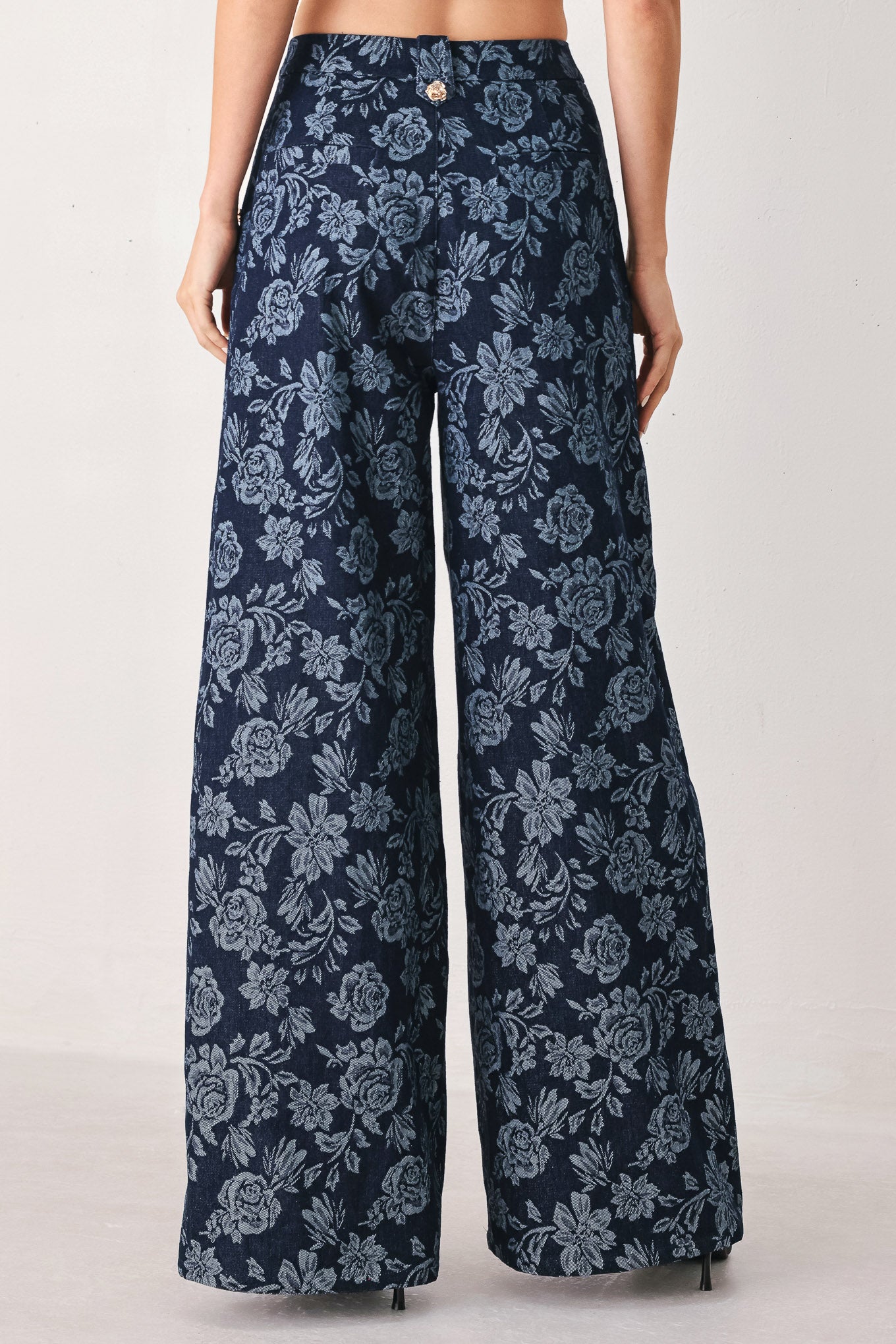 A woman wearing navy wide-leg jacquard pants with a light blue floral pattern and decorative buttons on the side | FREEMARKET