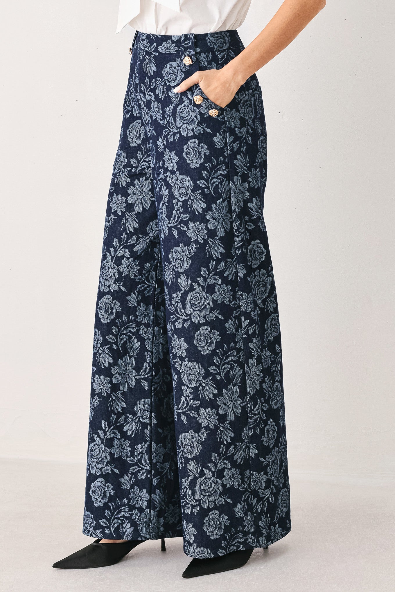 A woman wearing navy wide-leg jacquard pants with a light blue floral pattern and decorative buttons on the side | FREEMARKET