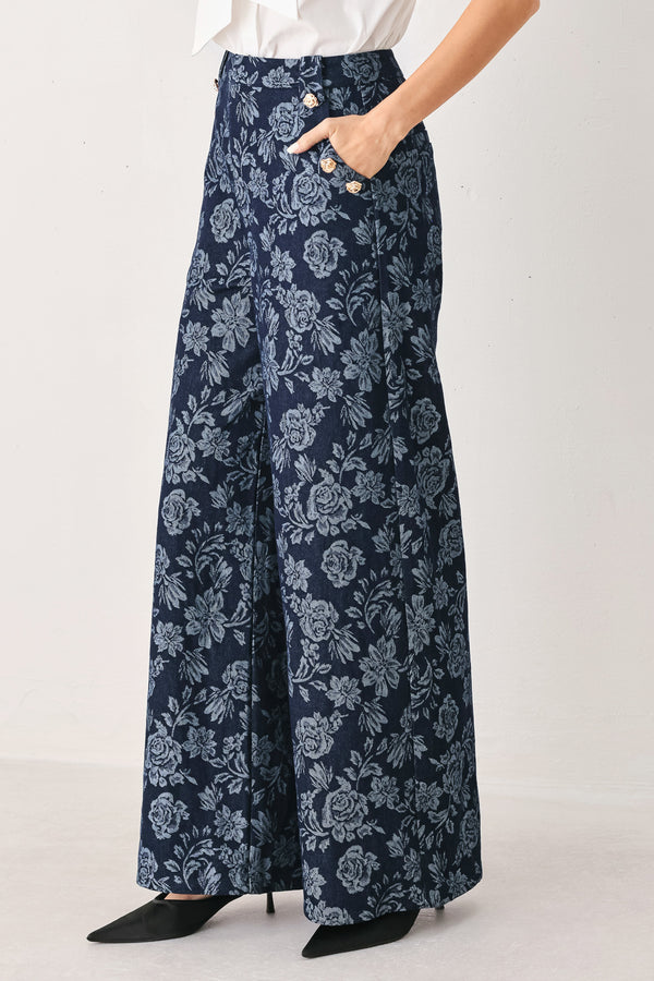 A woman wearing navy wide-leg jacquard pants with a light blue floral pattern and decorative buttons on the side | FREEMARKET