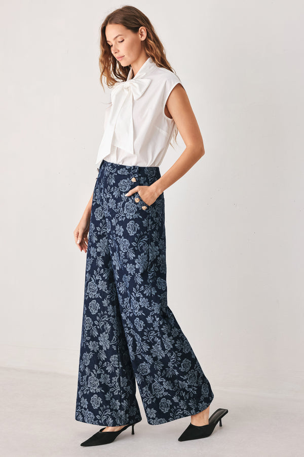 A woman wearing navy wide-leg jacquard pants with a light blue floral pattern and decorative buttons on the side | FREEMARKET