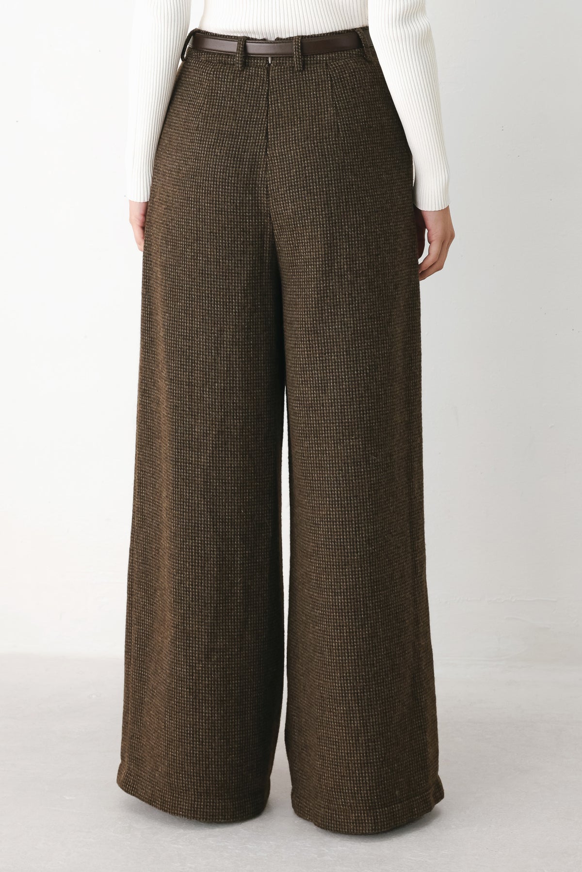 A person wearing high-waisted, wide-leg brown houndstooth trousers with a matching brown belt | FREEMARKET