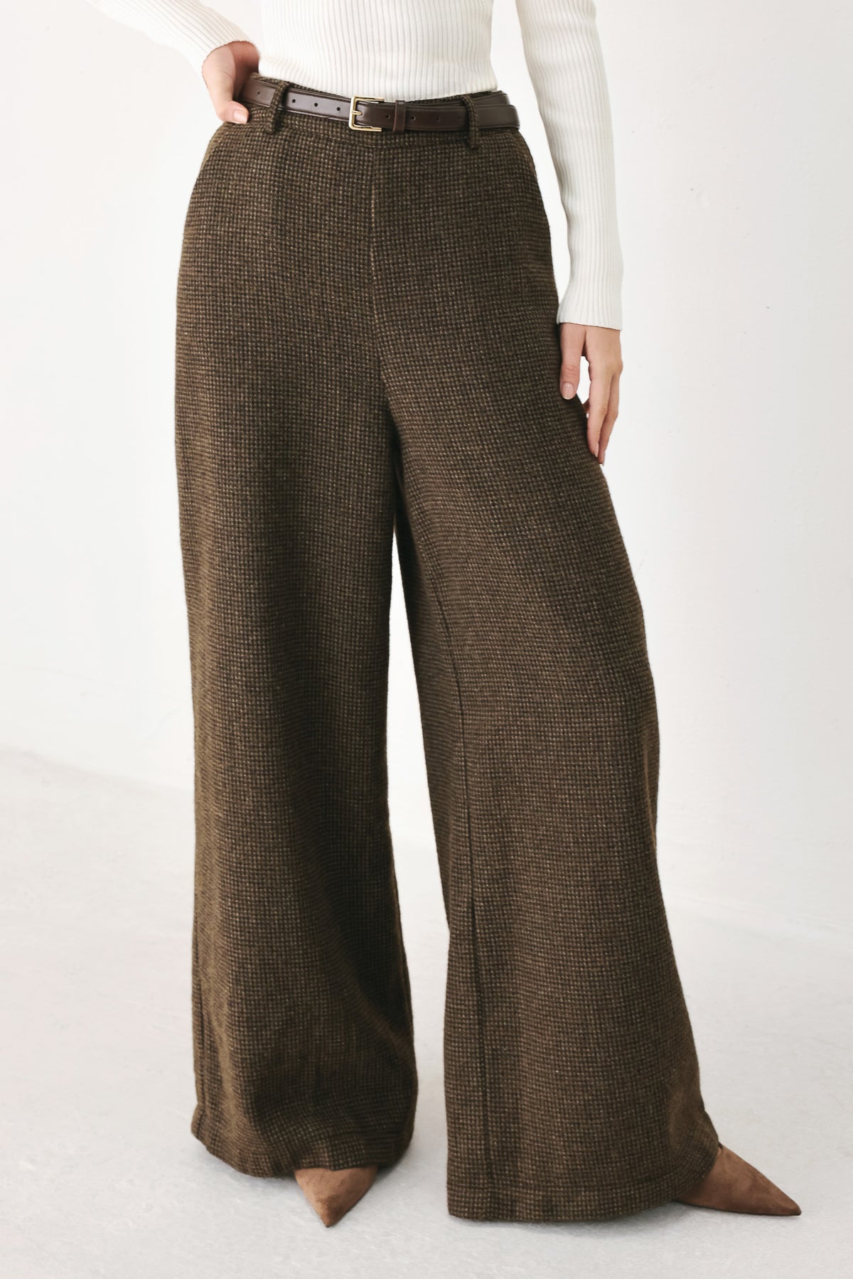 A person wearing high-waisted, wide-leg brown houndstooth trousers with a matching brown belt | FREEMARKET