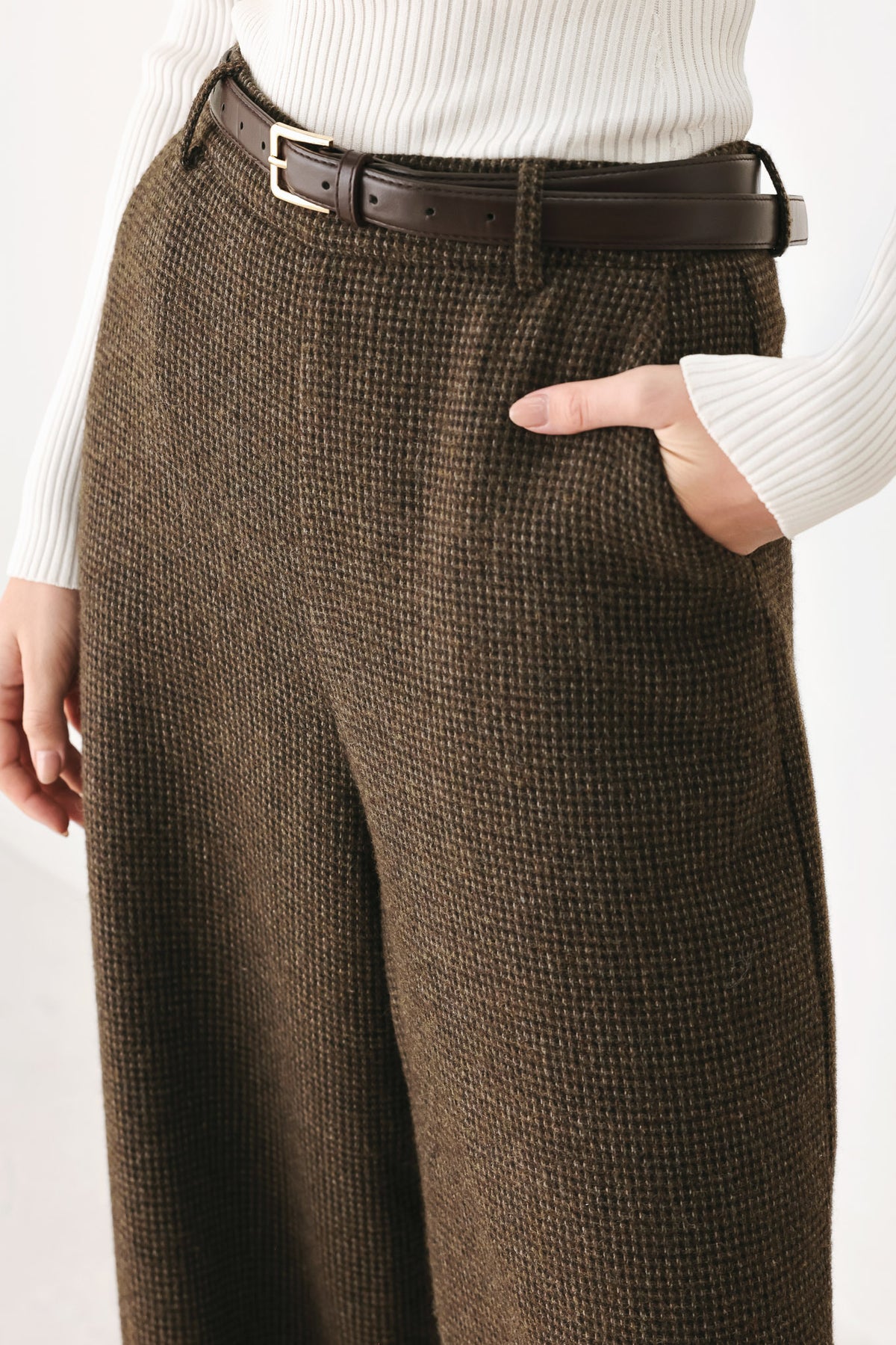A person wearing high-waisted, wide-leg brown houndstooth trousers with a matching brown belt | FREEMARKET