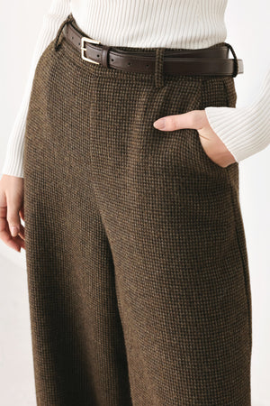 A person wearing high-waisted, wide-leg brown houndstooth trousers with a matching brown belt | FREEMARKET