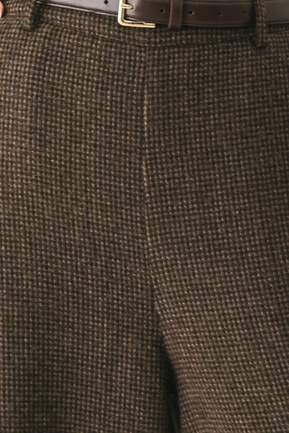 A person wearing high-waisted, wide-leg brown houndstooth trousers with a matching brown belt | FREEMARKET