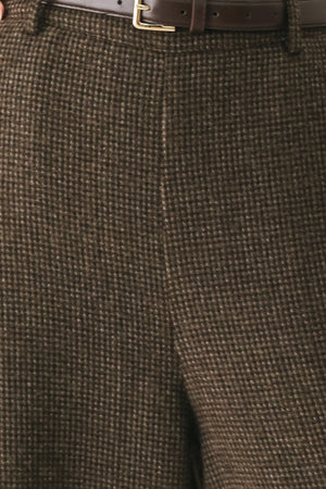 A person wearing high-waisted, wide-leg brown houndstooth trousers with a matching brown belt | FREEMARKET