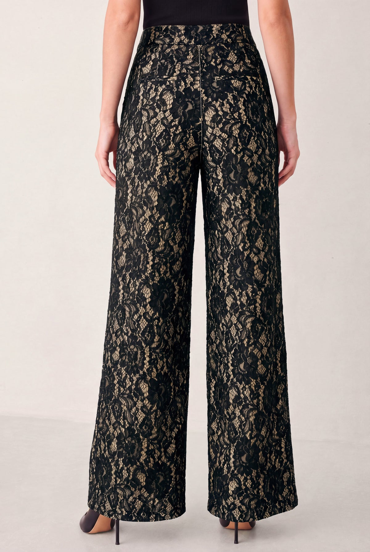 A model wearing high-waisted, wide-leg trousers featuring a black and beige floral lace pattern | FREEMARKET