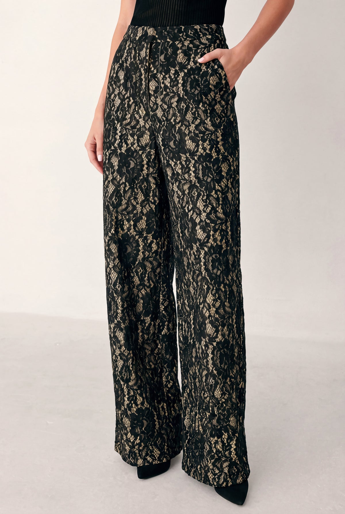 A model wearing high-waisted, wide-leg trousers featuring a black and beige floral lace pattern | FREEMARKET