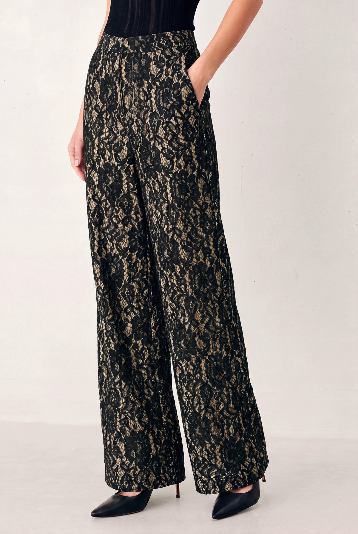 A model wearing high-waisted, wide-leg trousers featuring a black and beige floral lace pattern | FREEMARKET