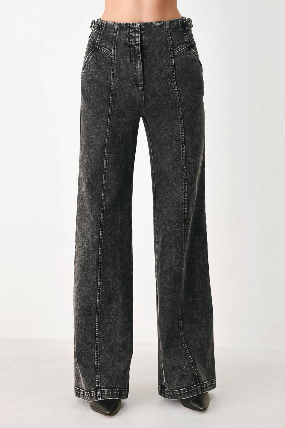 A pair of high-waisted, wide-leg jeans in a washed black or charcoal gray denim, shown on a model | FREEMARKET