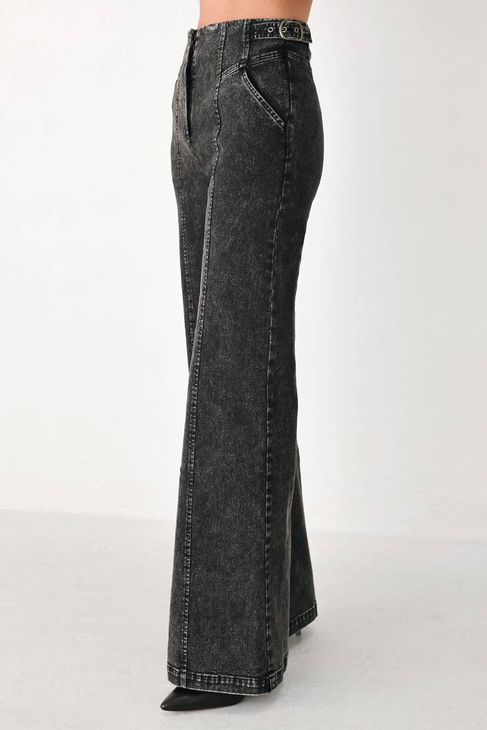 A pair of high-waisted, wide-leg jeans in a washed black or charcoal gray denim, shown on a model | FREEMARKET