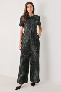 Woman wearing a black houndstooth shot sleeve jumpsuit | FREEMARKET