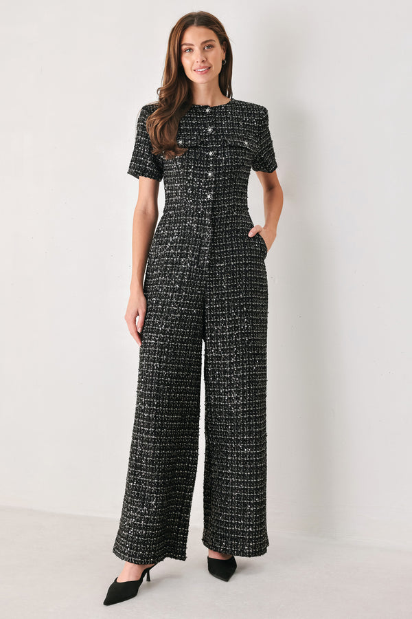 Woman wearing a black houndstooth shot sleeve jumpsuit | FREEMARKET