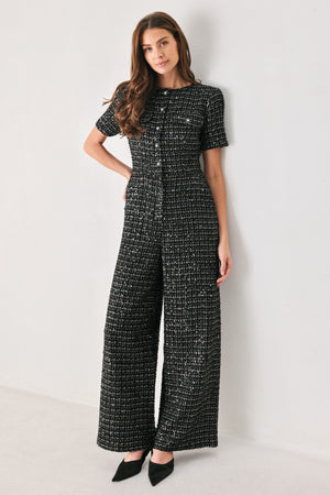 Woman wearing a black houndstooth shot sleeve jumpsuit | FREEMARKET