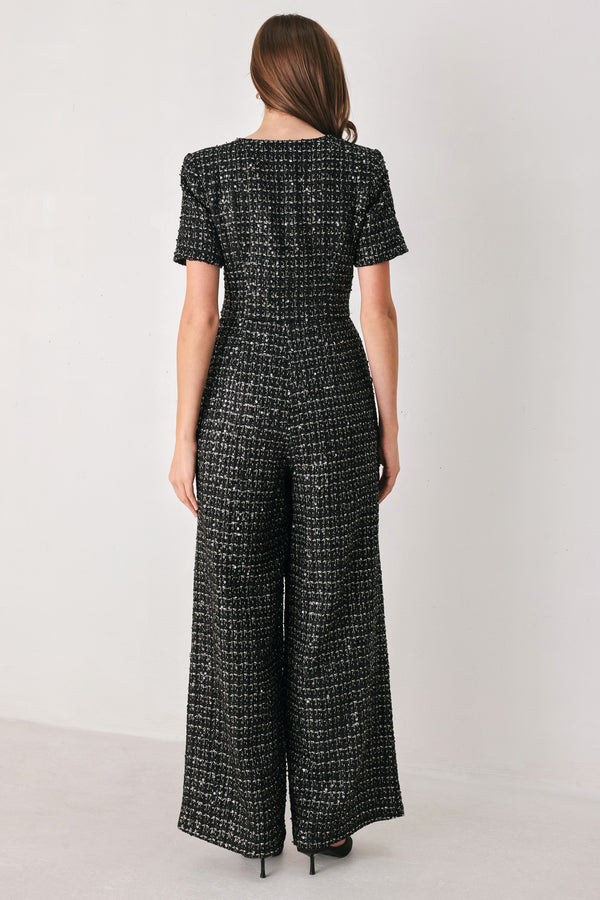 Woman wearing a black houndstooth shot sleeve jumpsuit | FREEMARKET