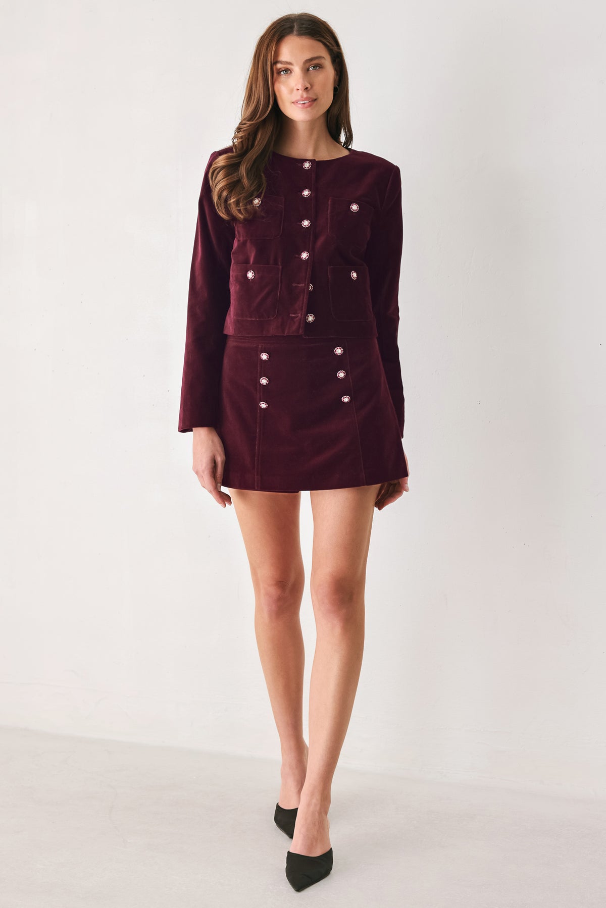 Woman wearing a burgundy velvet skort with buttons | FREEMARKET