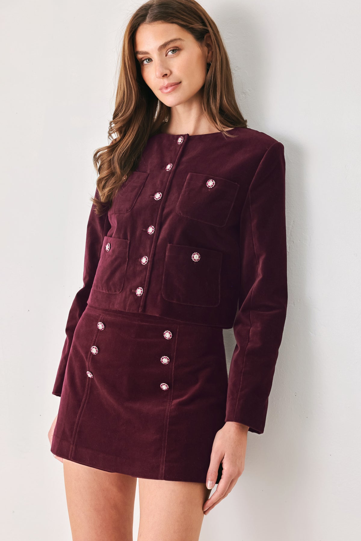 Woman wearing a burgundy velvet skort with buttons | FREEMARKET