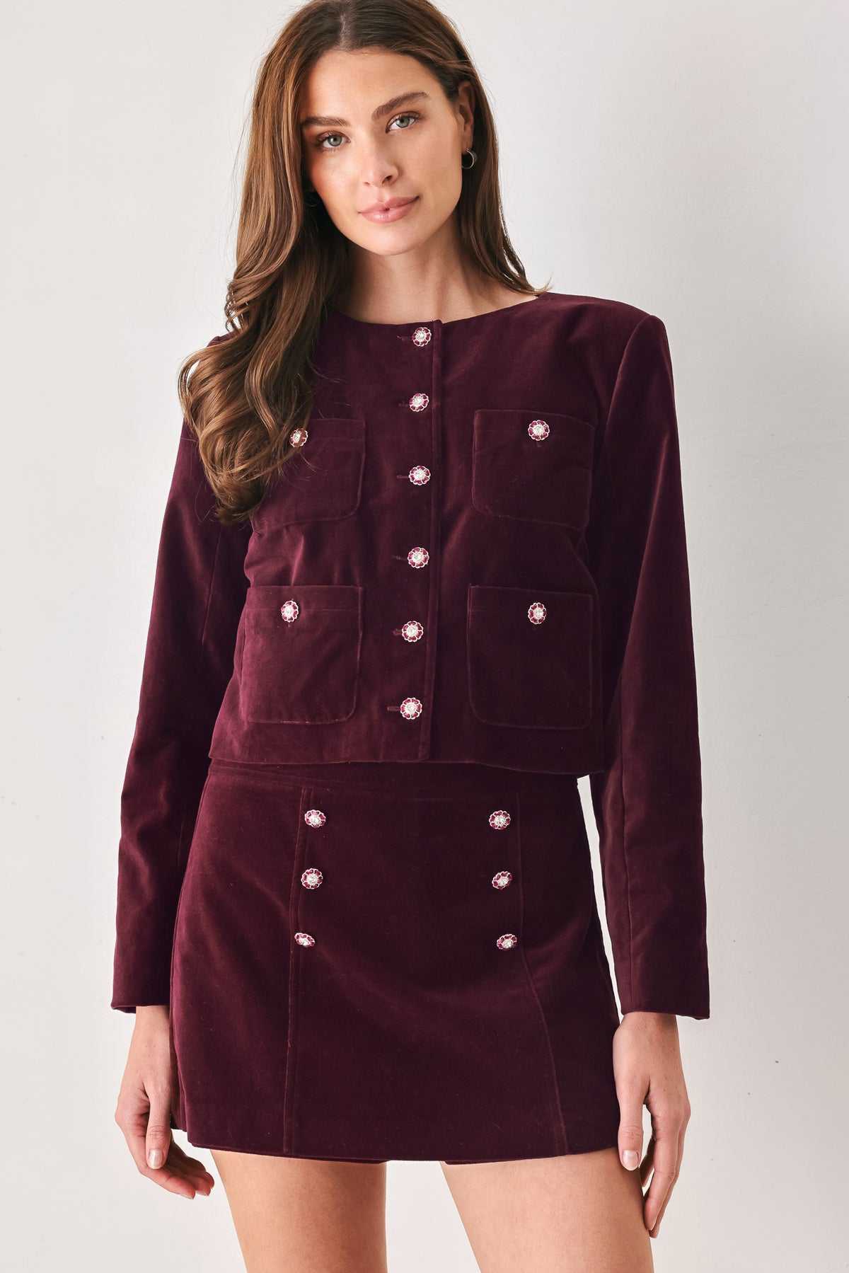 Woman wearing a burgundy velvet skort with buttons | FREEMARKET