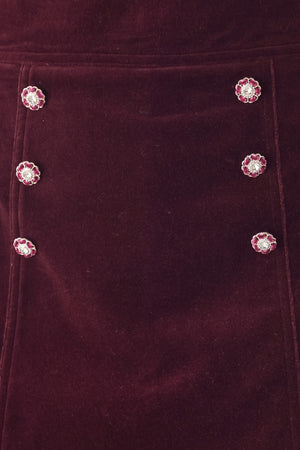 Woman wearing a burgundy velvet skort with buttons | FREEMARKET